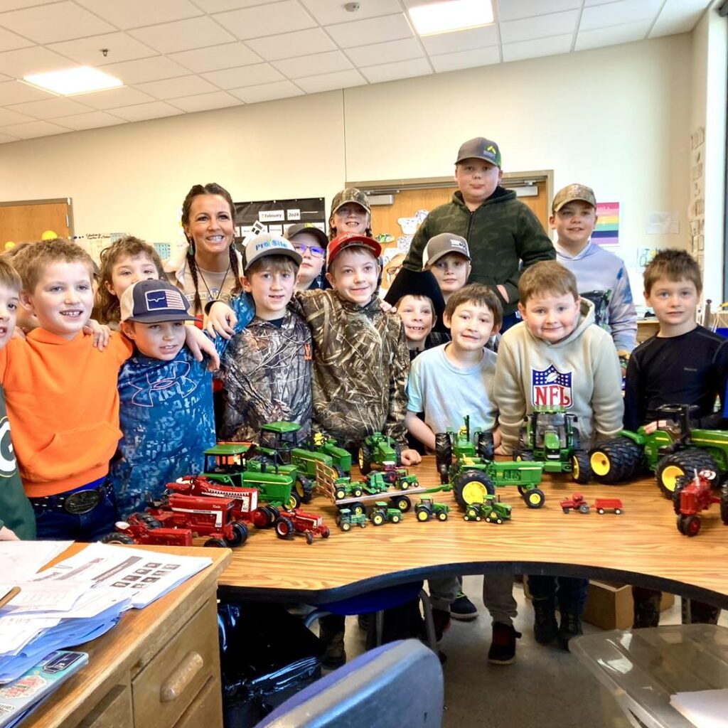 Teacher posing with students in class, Wisconsin.